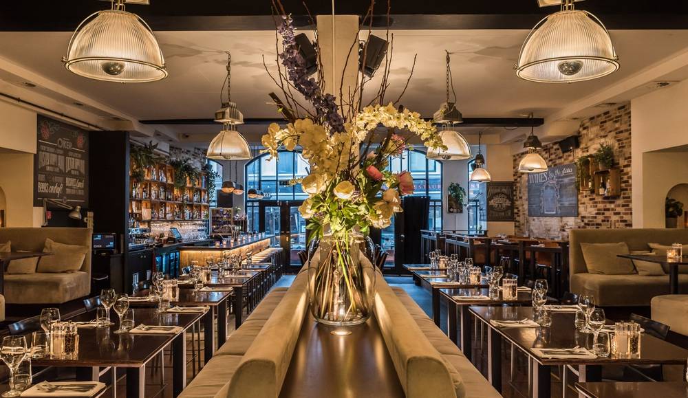 De lange tafel en de bar van Oker met bloemen
