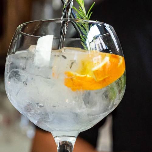 Een gin-tonic met sinaasappel en rozemarijn